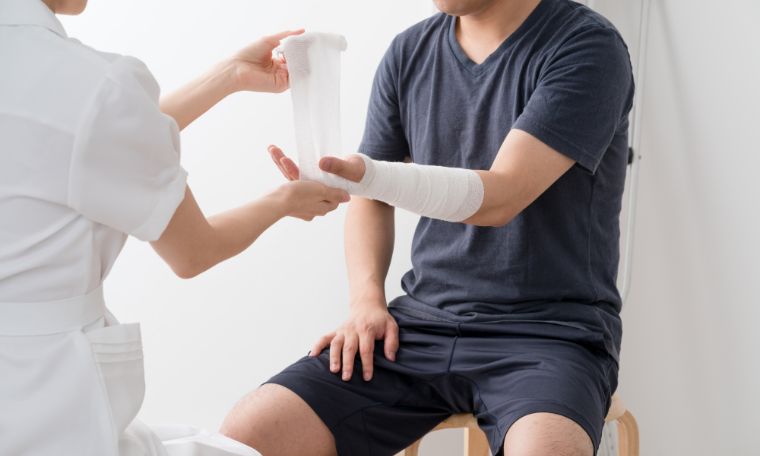 スポーツによるけがに包帯で処置する様子